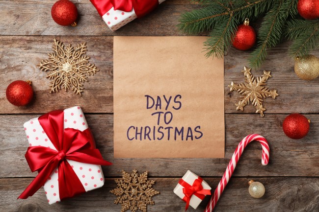 Χαρτί που γράφει "Μέρες για τα Χριστούγεννα". Γύρω του υπάρχουν χριστουγεννιάτικο δέντρο και δώρα