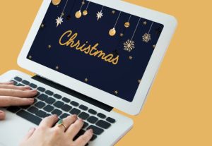 Θεματική εικόνα για ιδέες για χριστουγεννιάτικο μάρκετινγκ. Λάπτοπ στην οθόνη του οποίου αναγράφεται η λέξη "Χριστούγεννα".